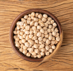 Raw chickpeas on a bowl over wooden table