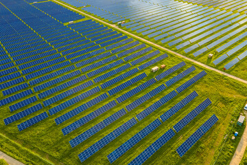 Aerial view of large sustainable electrical power plant with many rows of solar photovoltaic panels for producing clean ecological electric energy. Renewable electricity with zero emission concept