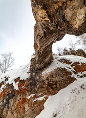 Winter landscape with a large stone from a frozen river