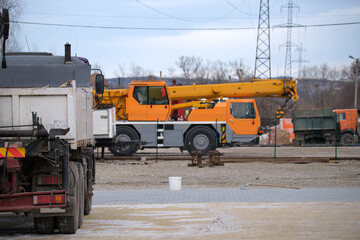 Heavy duty truck and mobile lifting crane at construction site