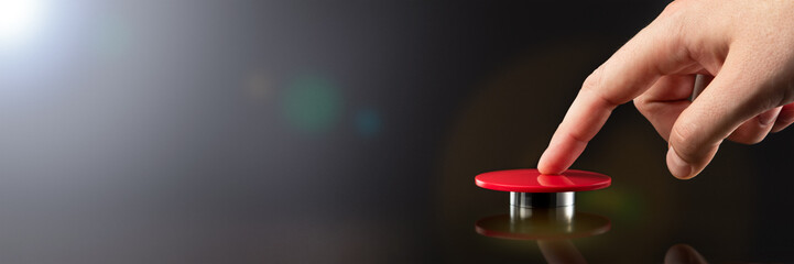 The hand presses the big red button. The concept of the threat of nuclear war. A threat to the world with a nuclear suitcase and a bomb. The hand presses the rocket launch button.