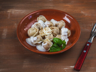 Meat dumplings for breakfast with basil leaves on a clay plate