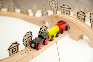 Wooden railway with steam train. Kids toy on wooden floor. Children room theme. Symbolic of careless childhood, dreams, war and easy life.