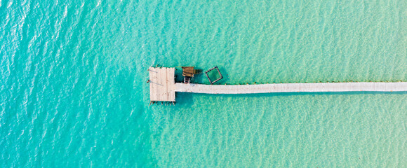 Aerial view. Beautiful tropical beach and wooden bridge in the sea in island Koh Kood Thailand. Banner panorama background.