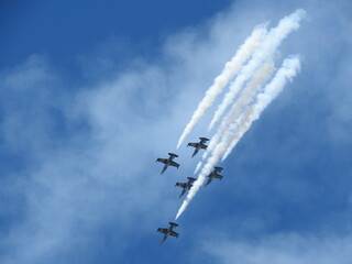 Aircraft performing aerobatic stunts at an airshow in the skies of southern California.