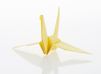 Yellow origami paper crane on white background