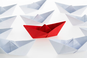 Red paper boat stands out
