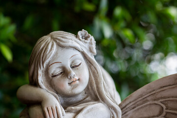 Close-up of the face of a girl statue with bokeh background.