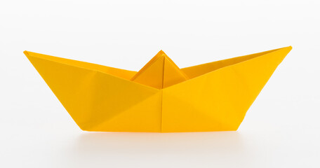 Yellow origami boat on white background