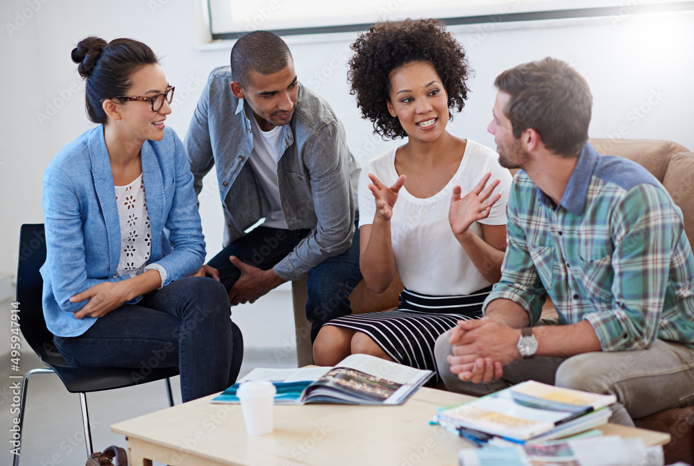 Poster were making progress. shot of a group of designers having a meeting around a coffee table.
