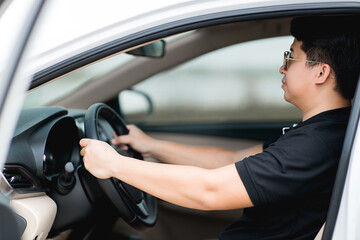 Fototapeta na wymiar Asian man driving a car on the road. Driving car concept.