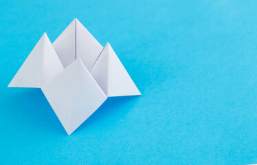 Origami paper fortune on blue background