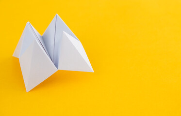 Origami paper fortune on yellow background