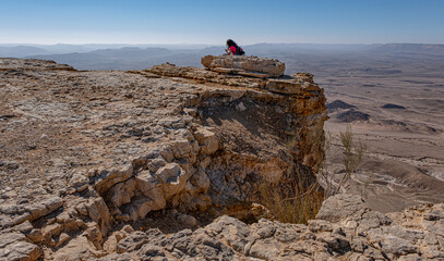 Hikers on the summit of  Mount Ardon, 300 m above  Ramon Crater below, Negev Desert, Southern Israel, Israel.			 - obrazy, fototapety, plakaty