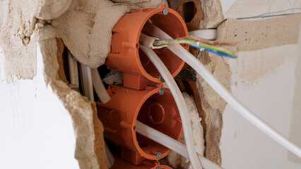 Close up of electrical wires hanging from a wall during apartment remodeling