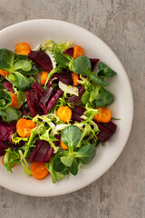 Warm salad with mixed salad with boiled carrots and beetroot with spices