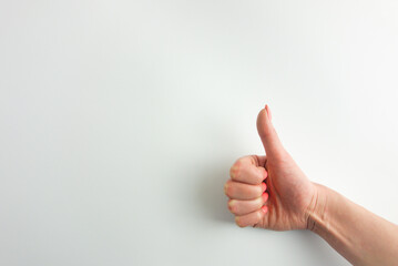 Female palm making thumbs up gesture. Woman's hand is isolated on white background