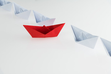 A red origami boat stands out
