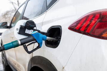 Gas station pistol in the tank of a car. Crisis in the supply of petroleum products. Close-up.
