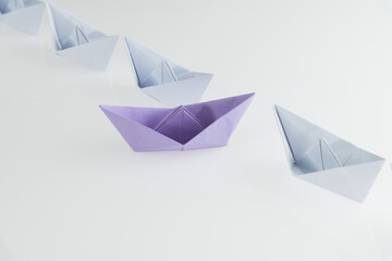 A purple origami boat stands out