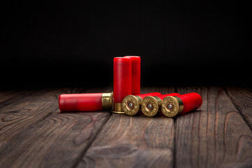 Shotgun cartridges on a brown wooden table. Ammunition for 12 gauge smoothbore weapons. Hunting...
