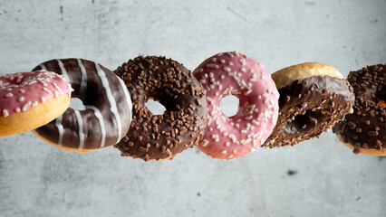 Levitating a variety of doughnuts on a gray background