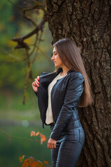 girl in black leather clothes near the tree