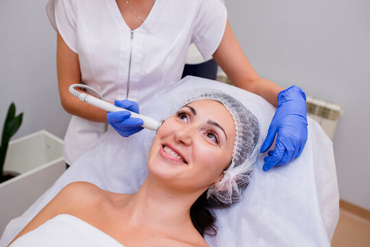 Facial procedure. Delighted nice woman lying on the medical bed with her eyes closed while having hydrafacial