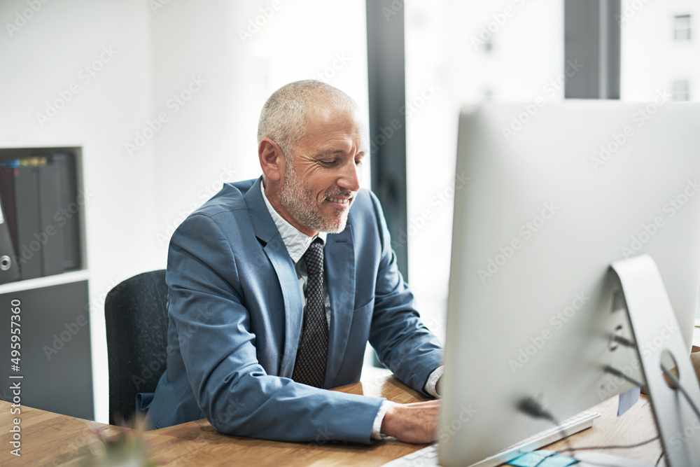 Poster business driven by the digital age. cropped shot of a mature businessman working on a computer in a 