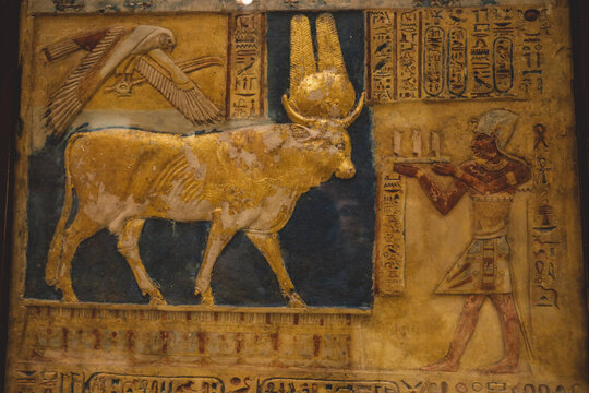 Cairo, Egypt - November 02, 2021: Stone Statue and Golden Painting of Ancient Egyptian Hathor Goddess, illustrated in the form of a cow