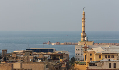 ALEXANDRIA, EGYPT - January 2022: Old Egyptian city rooftops, a minaret and sea view with historical buildings