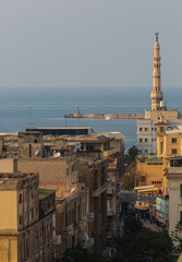 ALEXANDRIA, EGYPT - January 2022: Old Egyptian city rooftops, a minaret and sea view with historical buildings