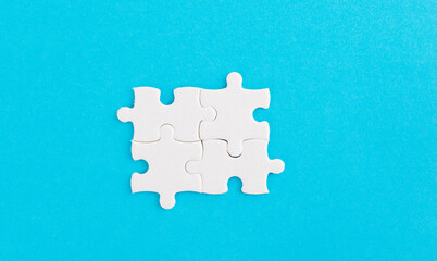 Four puzzle pieces on blue background