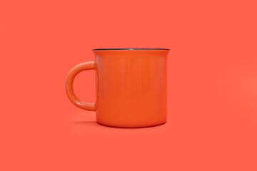 An orange mug on a bright orange background in the center. A large orange cup with a drink on an orange background. Cafe or snack concept. Bright colorful mug image