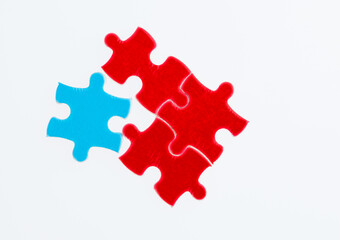 Three red and one blue puzzle pieces on white background