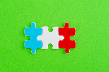 Three puzzle pieces on green background