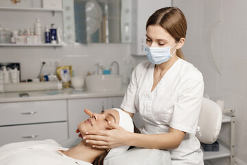 Obraz na płótnie Canvas cosmetological procedure for pretty female mask and massage