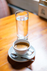 Cup of americano coffee and water glass.