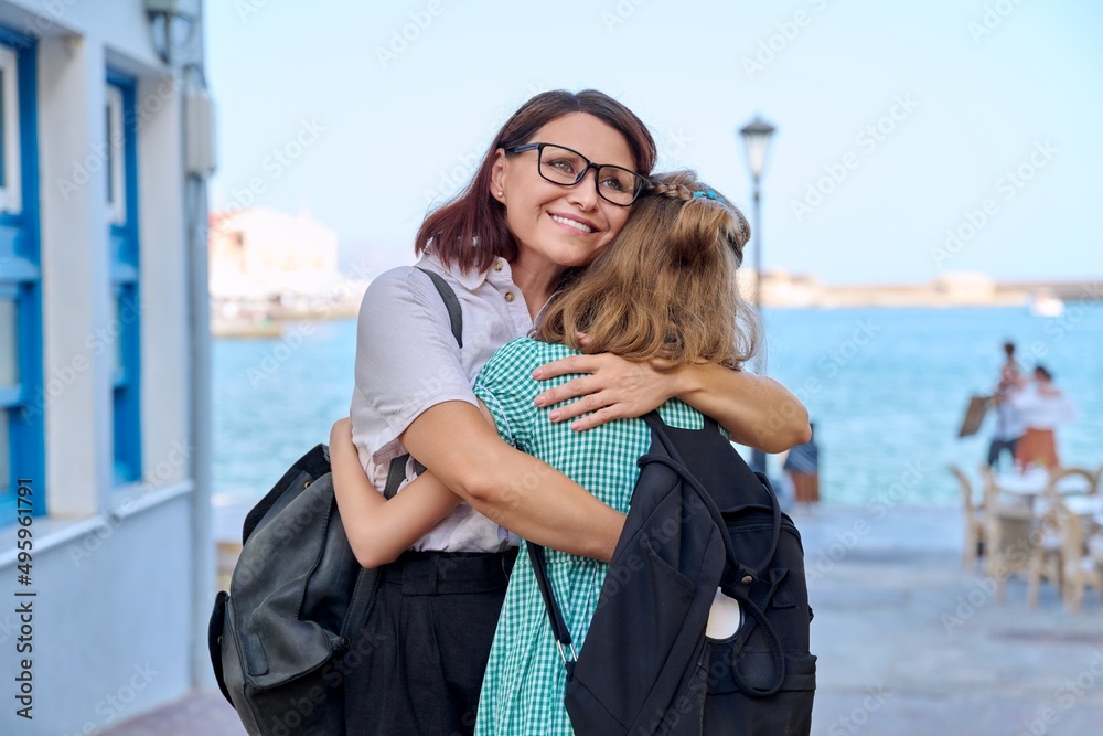 Poster Mom hugging daughter outdoors, happy mother's face close up