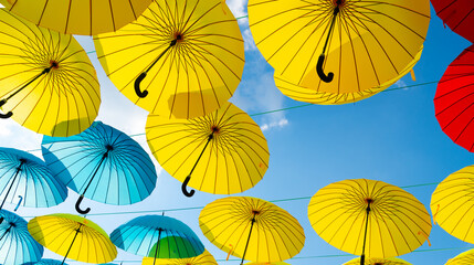Fototapeta na wymiar Colorful umbrellas background. Colorful umbrellas in blue sky. Street decoration