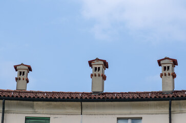 domestic heating: fireplaces, efficiency and cleaning increases safety and cuts costs. To heat the house, everything must be efficient. Roof of a historic building with decorative tiles and bricks.