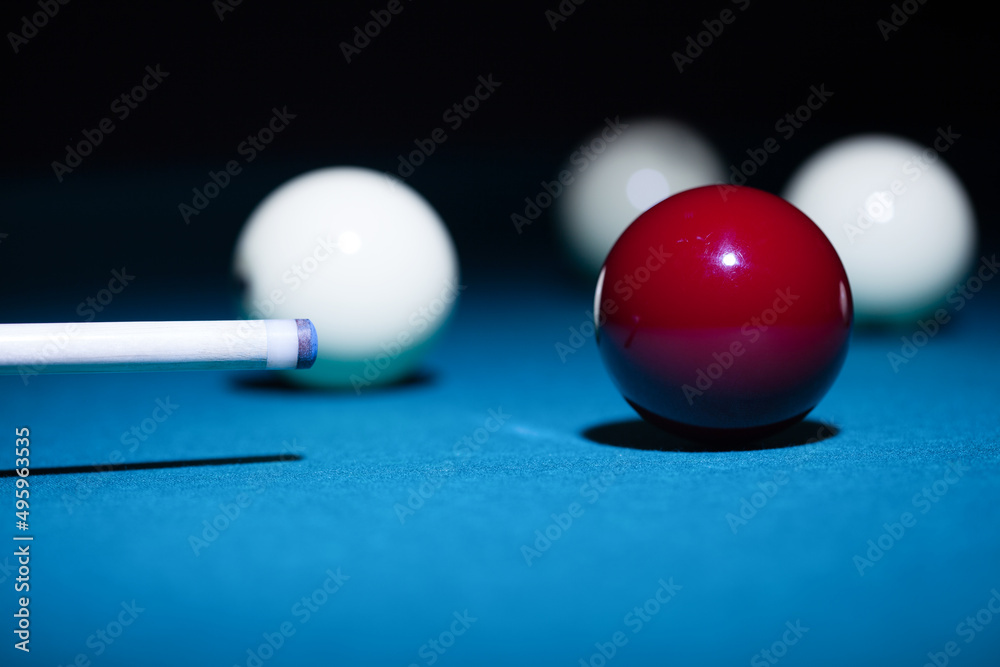 Wall mural man playing billiard sport game, red and white balls, cue and green pool table background