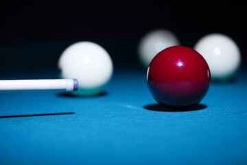 Man playing billiard sport game, red and white balls, cue and green pool table background