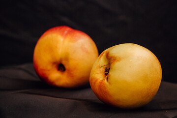 Two nectarines on a black background