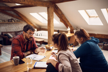 Young student talks to his female friends while learning together at home.
