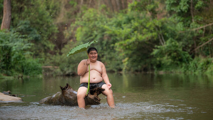 Boy smiling, playing in the river, waiting for the rain.. happiness of rural villagers, Laos, and nature