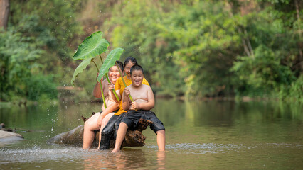 Happy Country Boy And Girl smiling Playing Water at the River in asian.