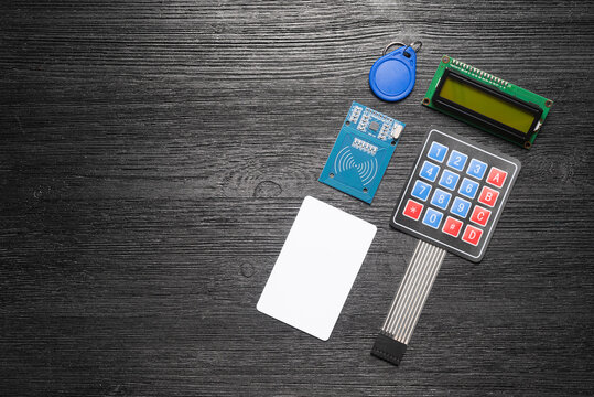 Door access control keypad, magnetic key, card and display on the black background.