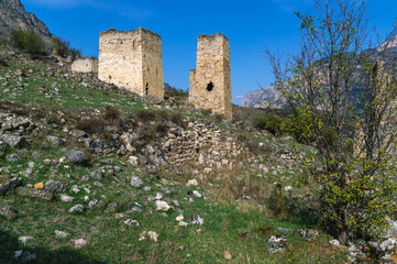 An ancient fortress structure for protection from attacks. An old medieval tower for watching enemies against the background of mountains.