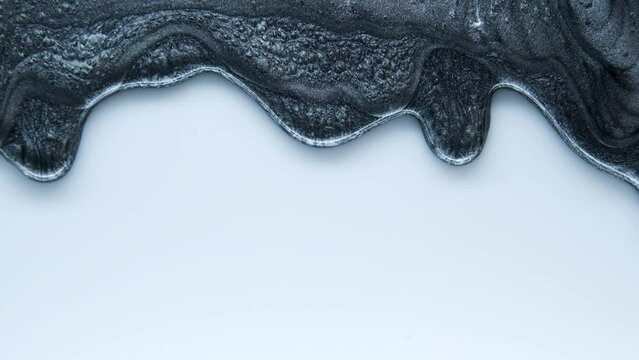 Black mother-of-pearl luminous liquid. Advertisement for minerals. Decorative cosmetics. Medical cosmetics for face and body.